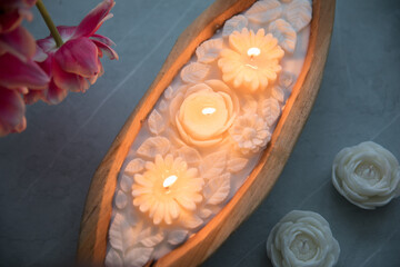 Candle in a wooden form in the shape of flowers