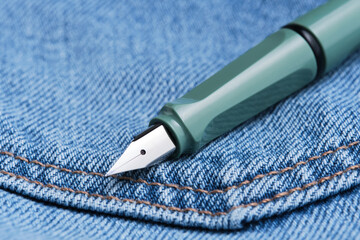 Green fountain pen is back pocket blue jeans.