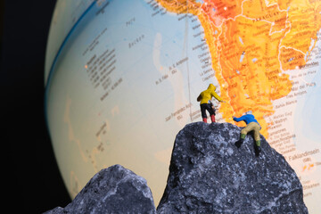 Bergsteiger klettern auf einen Globus, miniaturfiguren fotografie