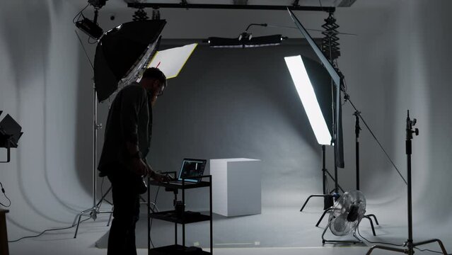 Male photographer working in the photo studio, looking at the laptop