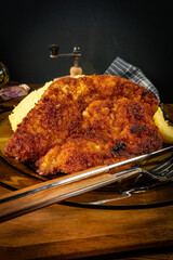 Breaded pork neck cutlet served with potatoes and salad.