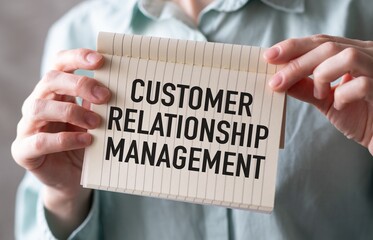Businesswoman holding a sign with the words Customer Relationship Management written on it.