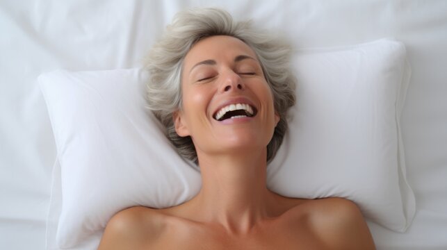 Women's pleasure. A beautiful female with soft skin is enjoying and feels good. Female orgasm. Lying on a white bed