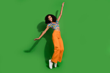 Full body length size photo of funky american girlfriend with chevelure hairstyle stand tiptoes in dance isolated on green color background