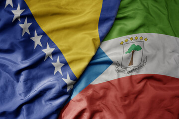big waving national colorful flag of equatorial guinea and national flag of bosnia and herzegovina.