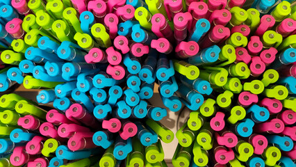 Abstract background of multicolored caps of plastic pens. A set of several liners, markers and...