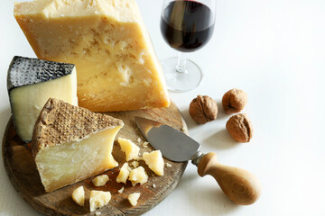 Diversi tipi di formaggi a pasta dura con frutta e vino isolati su sfondo bianco. Cibo italiano....