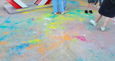 After the celebration of Holi, scattered paints on the asphalt