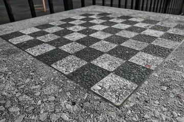 chessboard on a stone table in a public park (brooklyn new york city) chess board checkered squares...