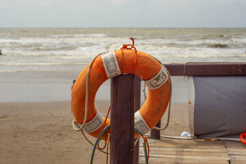 Salvavidas naranja en puesto de guardavidas en la playa - obrazy, fototapety, plakaty