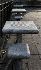 chessboard on a stone table in a public park (brooklyn new york city) chess board checkered squares...
