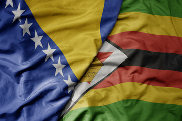 big waving national colorful flag of zimbabwe and national flag of bosnia and herzegovina.