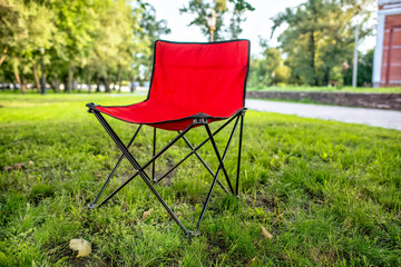Folding chair for picnics outside the city on the lawn in the autumn park.