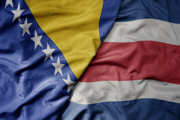 big waving national colorful flag of costa rica and national flag of bosnia and herzegovina.