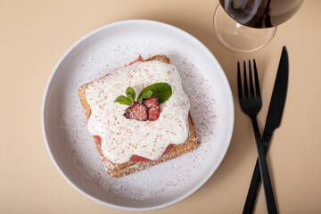 Belgian waffles with strawberry confit and cream sauce on beige background top view
