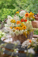 Układanie letnich, kolorowych kwiatów w koszyku wiklinowym