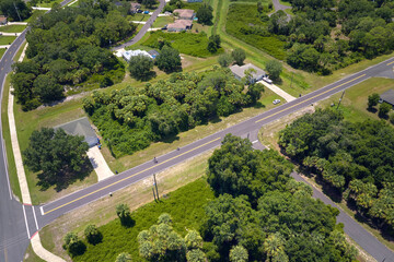 Aerial view of street traffic with driving cars in small town. American suburban landscape with...