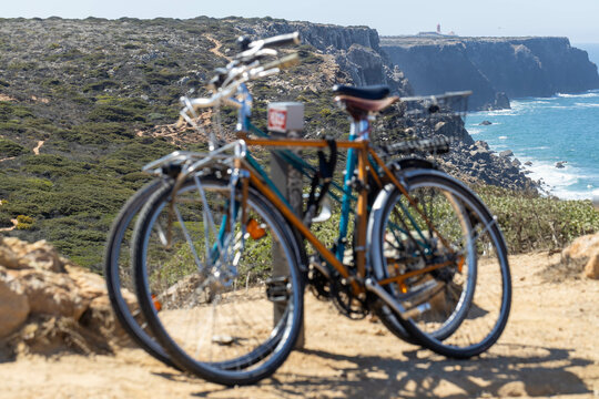 Blurred bicycles on a rack with a sharp background of the coast with a cliff
