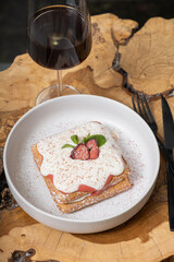 Belgian waffles with strawberry confit and cream sauce on a wooden table in a cafe