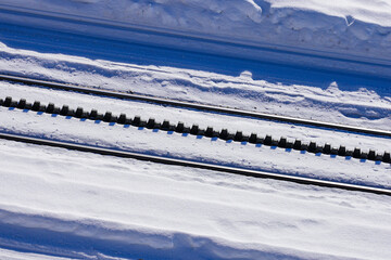 Snowy cogwheel railroad equipped with a rack rail using the Abt system with 2 solid bars with...