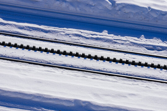 Snowy cogwheel railroad equipped with a rack rail using the Abt system with 2 solid bars with offset pinions in the Gornergrat summit train station above Zermatt, Valais, Switzerland