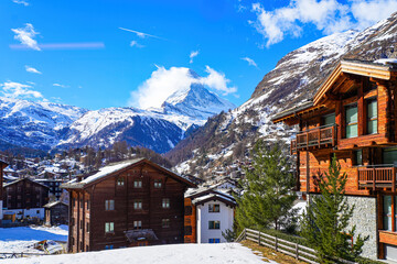 Wooden chalets in the village of Zermatt overlooked by the Matterhorn peak in the Swiss Alps in...