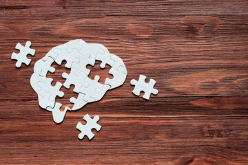 Incomplete Mind: Brain Puzzle with Missing Pieces on Wooden Background