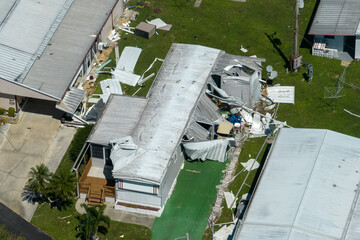 Hurricane destroyed suburban houses roofs in Florida mobile home residential area. Consequences of...