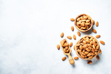 Almond nuts in wooden bowl at white background.