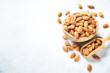 Almond nuts in wooden bowl at white background.