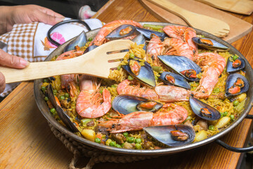 Seafood paella with shrimp and mussels in a pan, ready to be served with a wooden utensil, typical Spanish cuisine, Majorca, Balearic Islands, Spain