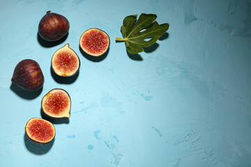 Fresh ripe figs and leaf on blue background