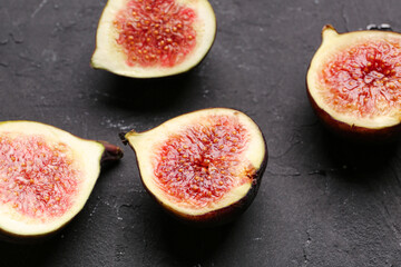 Halves of fresh ripe figs on black background