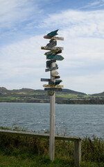 Signpost with multiple locations on the Porthdinllaen coastal path in Wales