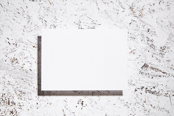 Single white blank card on textured splatter background, top view, flat lay