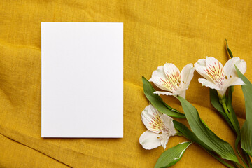 A white blank card ready for a personalized message, flanked by delicate white Alstroemeria flowers...