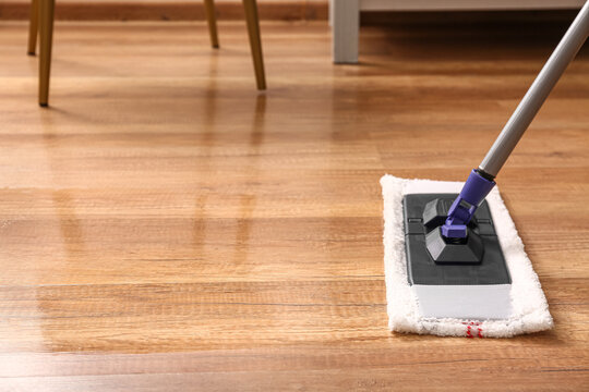 Cleaning of wooden laminate floor with mop, closeup