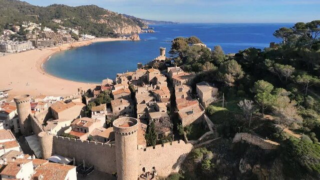 Panoramic aerial drone view of Spanish medieval town Tossa de Mar, harbour and park, 4K