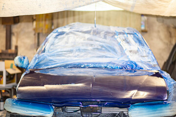 Fototapeta na wymiar painting a car blue in the garage, repainting the body.