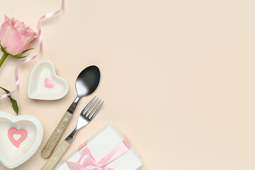 Beautiful table setting with pink rose and gift box on beige background. Valentine's Day celebration