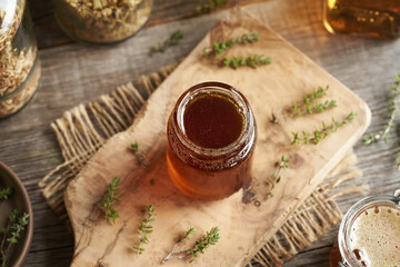 A jar of thyme syrup on a table