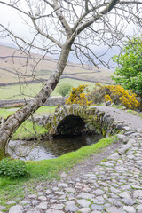 Stone arch bridge across a small stream in Lake District National Park.