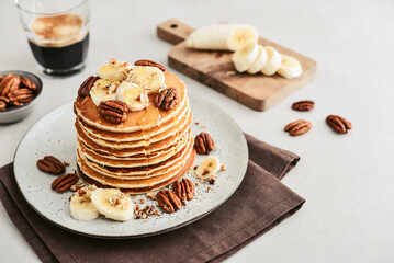 Plate of maple pecan pancakes with fresh bananas