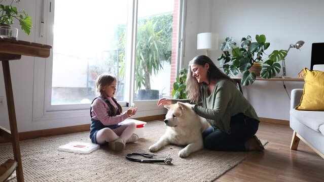 playing veterinary doctor with dog at home grandmother and granddaughter