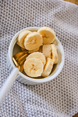 Bowl with slices banana and muesli on wood table. Healthy eating, healthy lifestyle. Breakfast concept.