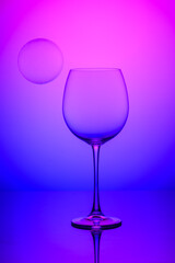 wine glass with soap bubbles on blue and pink background 2