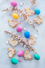 Homemade almond bunny cookies for Easter with colorful Easter eggs