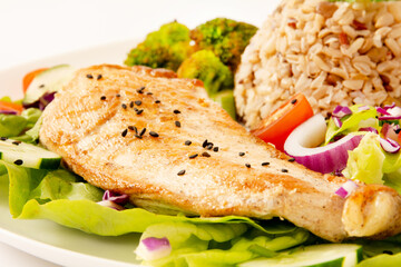 Grilled chicken in a plate with salad and rice isolated clean white background top view photo