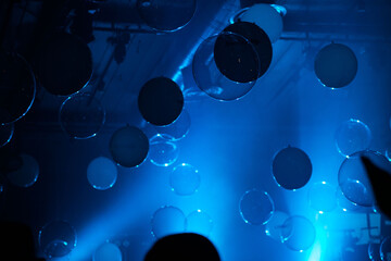 Striking abstract background with suspended, luminescent blue orbs and disks creating an...