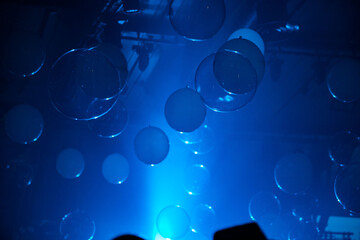 Striking abstract background with suspended, luminescent blue orbs and disks creating an...